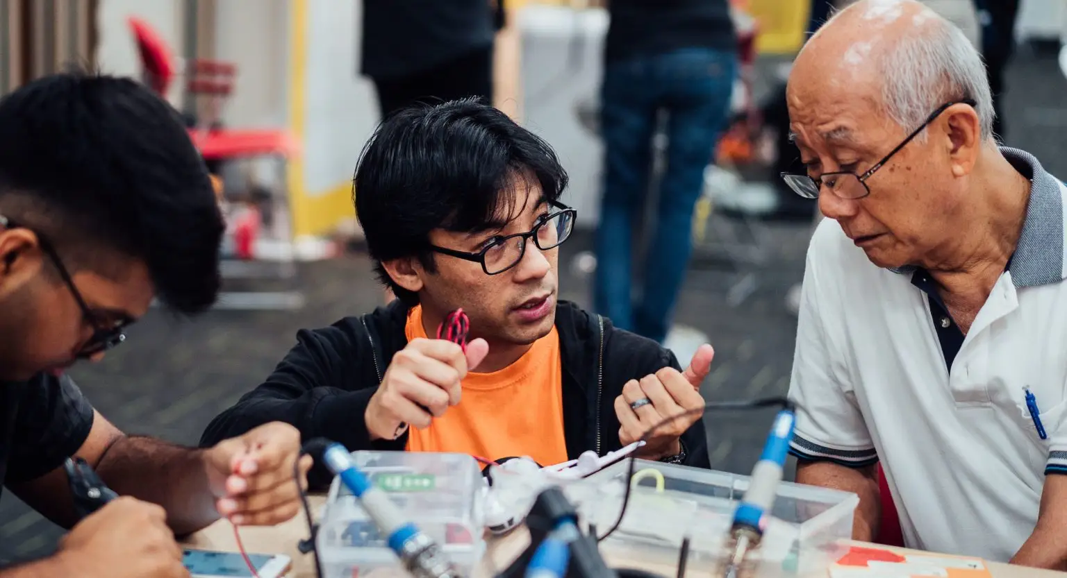 Engineering Good volunteer and an elderly man at an assistive technology workshop. EG is a tech and engineering charity in Singapore that empowers vulnerable and low-income communities, serving over 200 social service agencies.